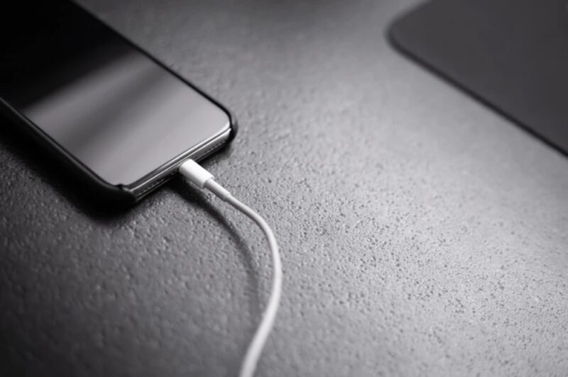 A black phone plugged the charger